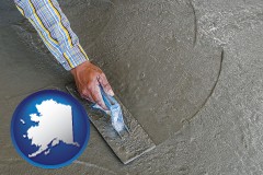 alaska map icon and smoothing a concrete surface with a trowel