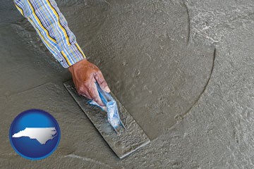smoothing a concrete surface with a trowel - with North Carolina icon